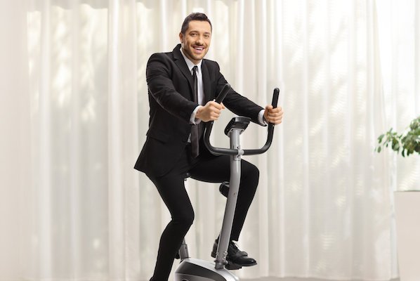 business man in suit on stationary bicycle