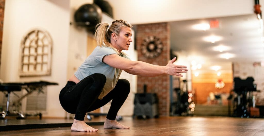 a woman doing a squats physical therapy exercise