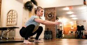 a woman doing a squats physical therapy exercise