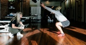 a woman therapist teaching a man the best at home physical therapy exerises