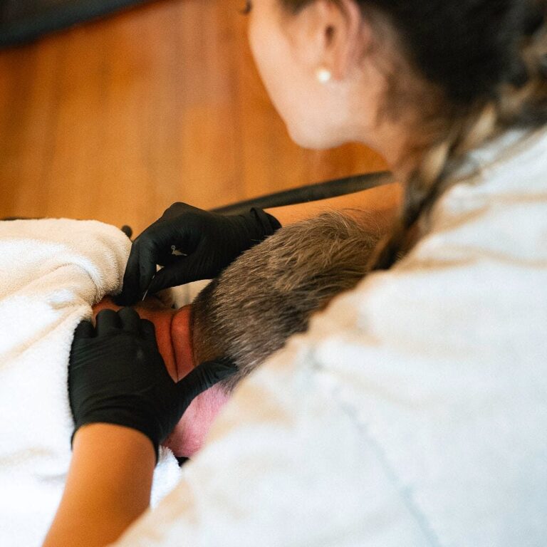 Physical therapist performing manual therapy on a patient's neck to relieve pain and stiffness.