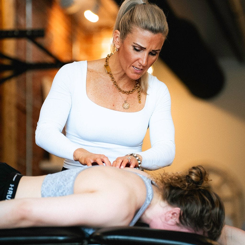 Physical therapist performing a comprehensive head-to-toe movement assessment on a patient.