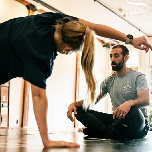 Physical therapist coaching a patient during rehabilitation training