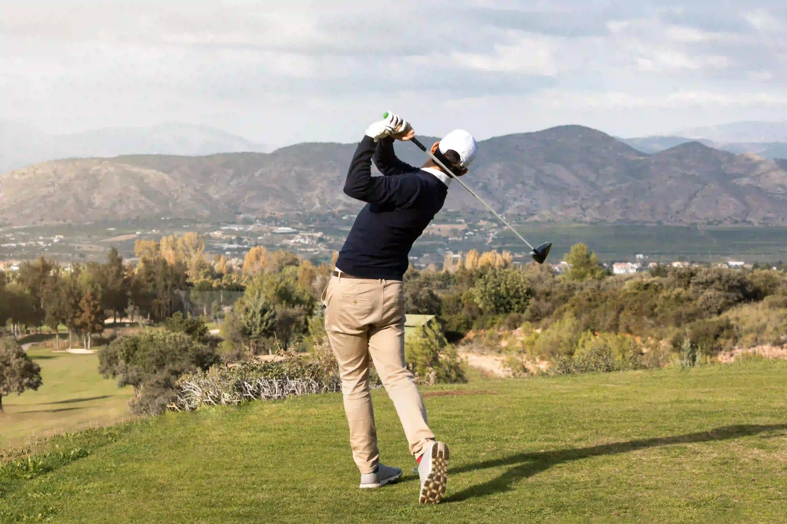 Physical therapist assessing a golfer's hip rotation and flexibility to identify movement deficits.