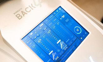 Physical therapist applying TECAR therapy using a radiofrequency electrode on a patient.