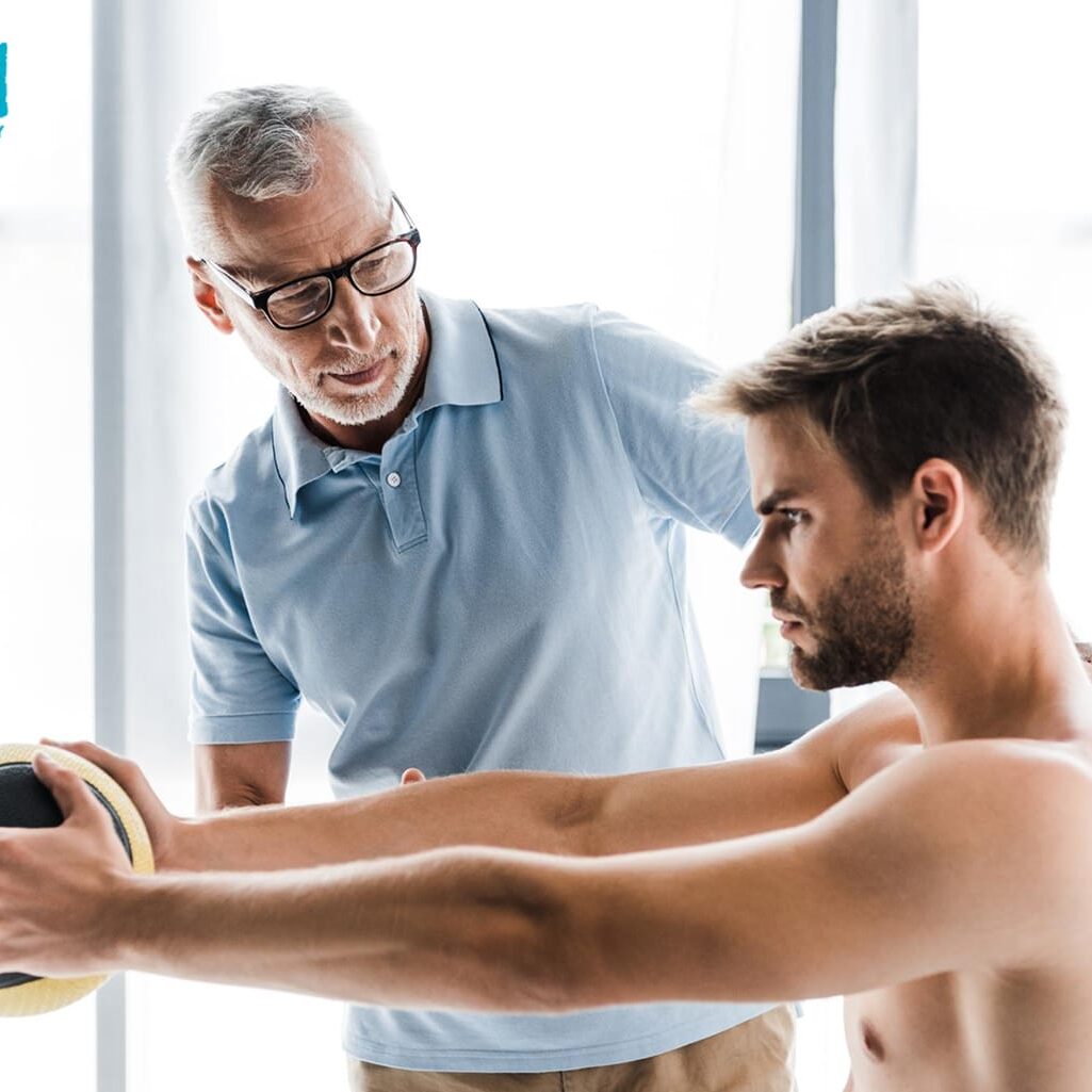 A therapist guiding an athlete through shoulder pain therapy exercises.